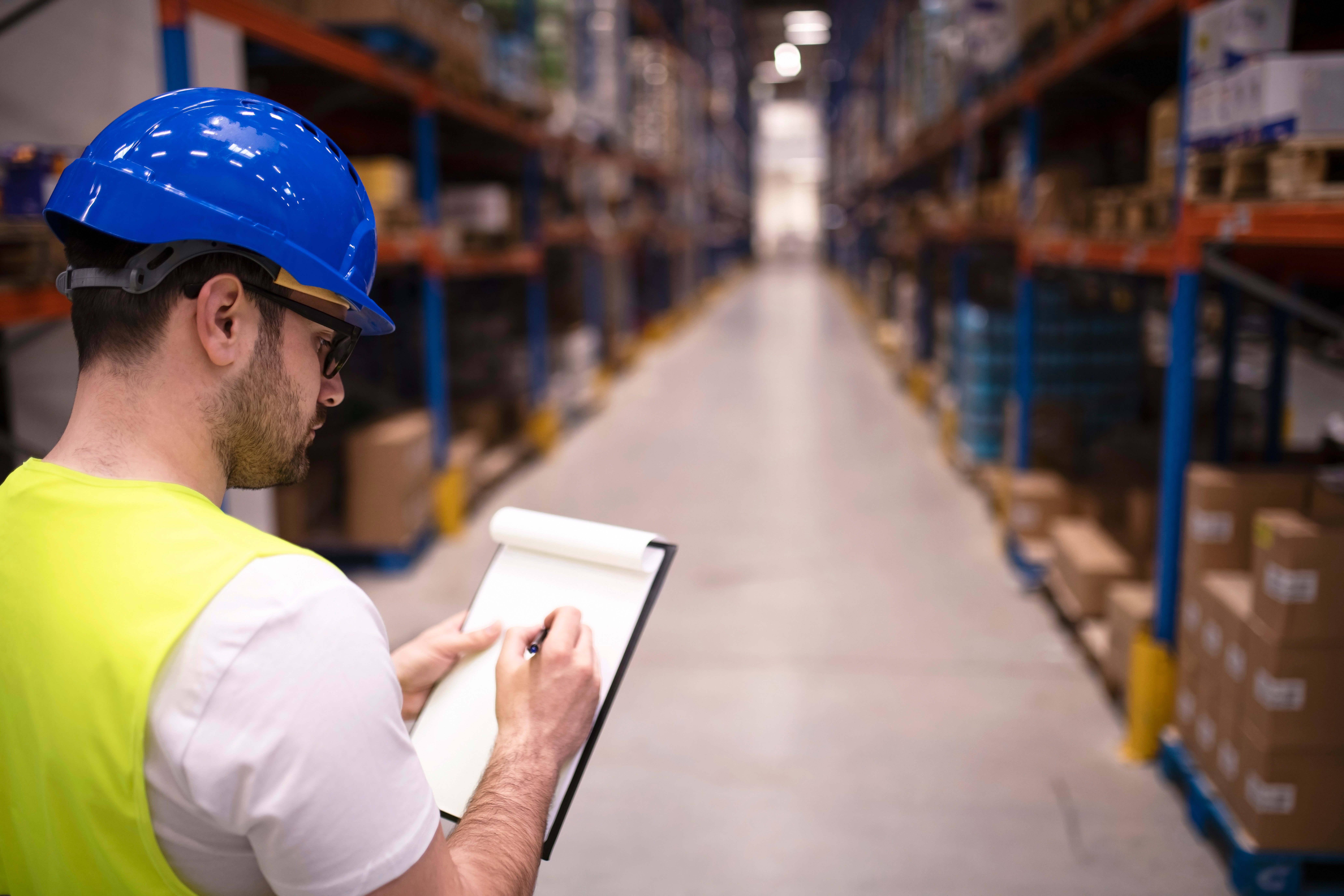 factory-worker-holding-clipboard-and-checking-inventory-of-warehouse-storage-department